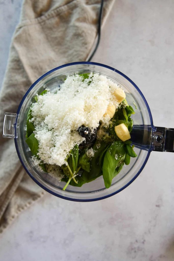 Ingredients for pesto sauce in a food processor. 