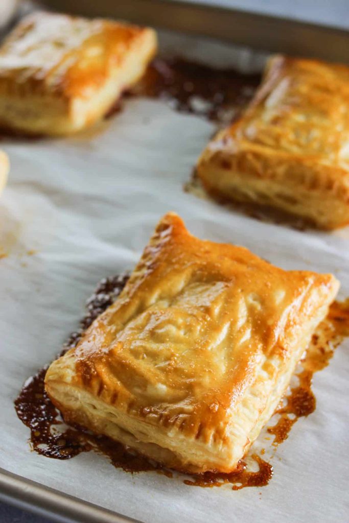 Puff pastry tarts on a baking sheet lined with parchment. 