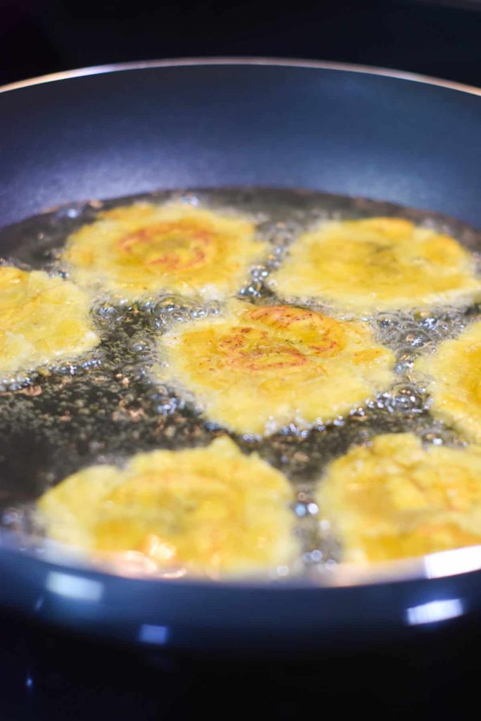 Smashed plantains in the frying oil to get fried for the second time. 