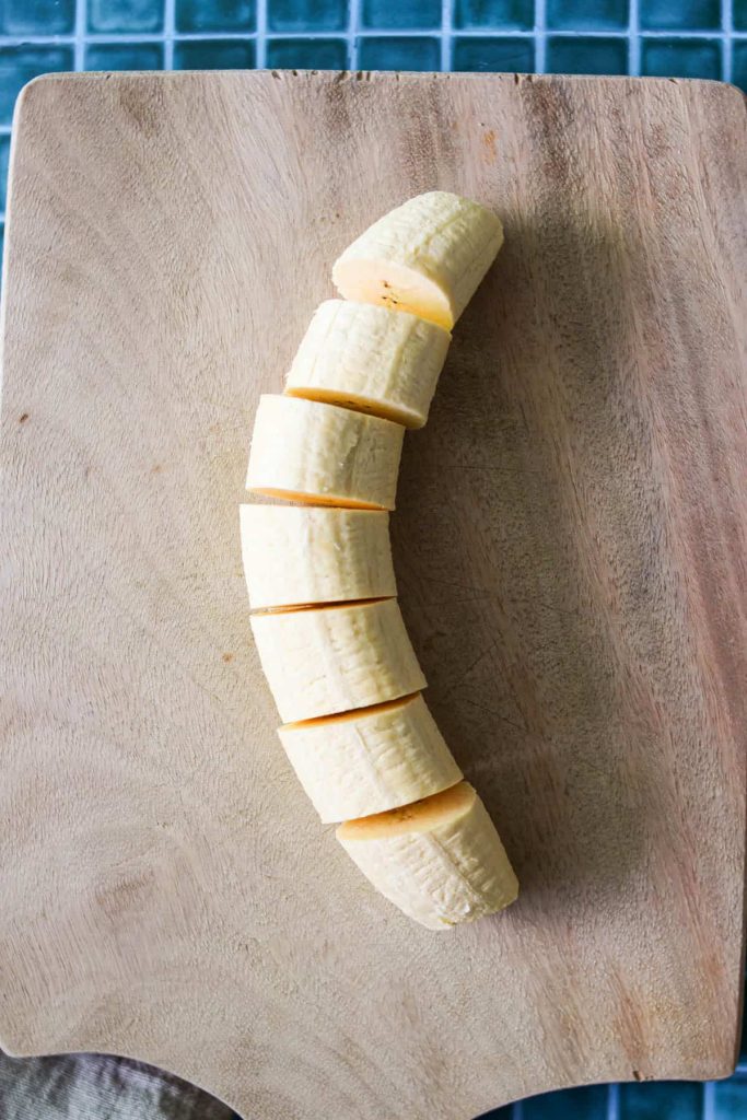 Plantain cut into 1 inch pieces on a cutting board. 