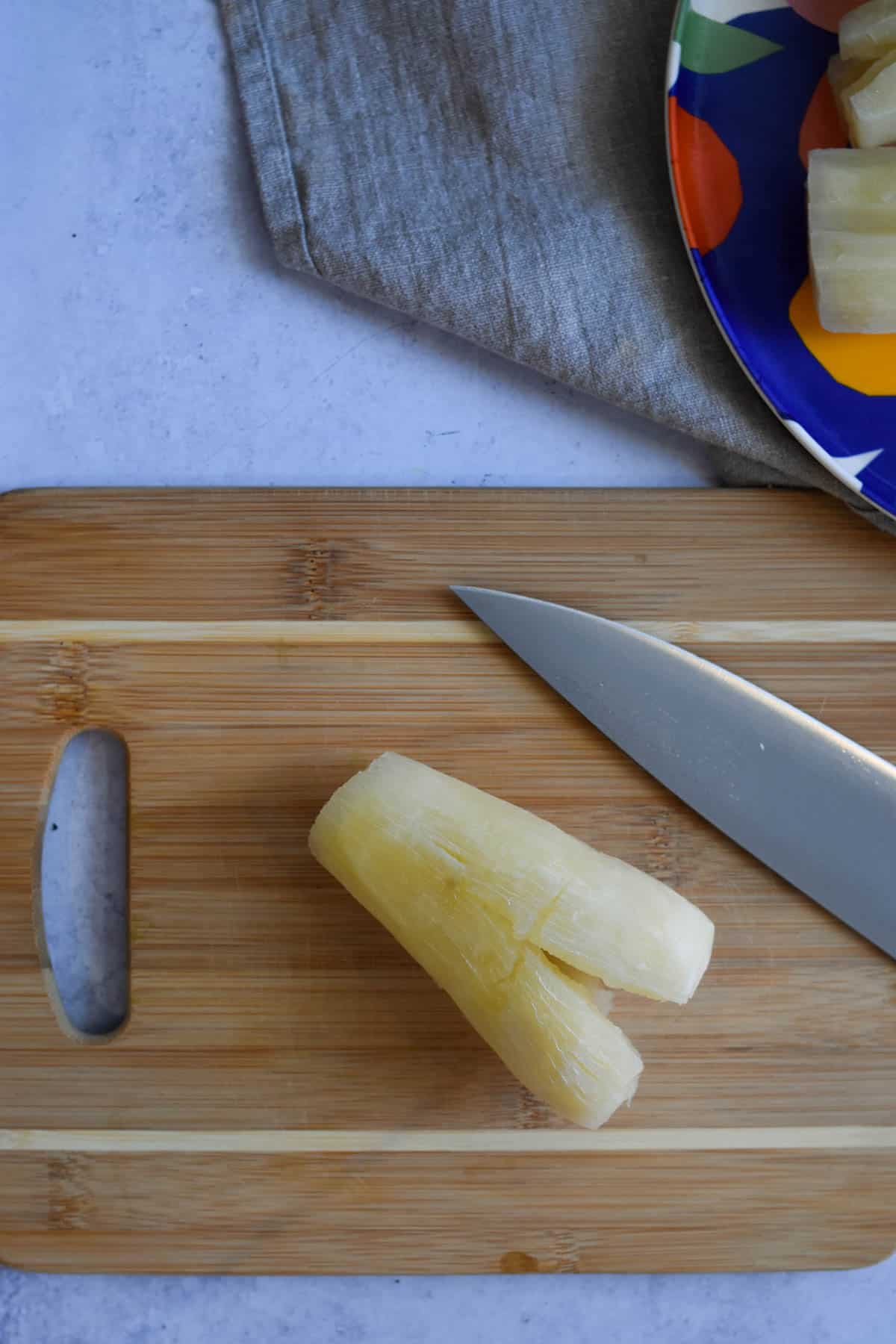 Piece of boiled yuca on a cutting board. 