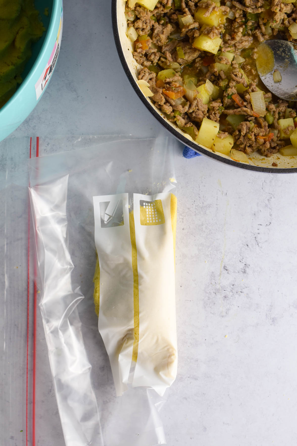 Empanada dough folded over the filling using the bag. 