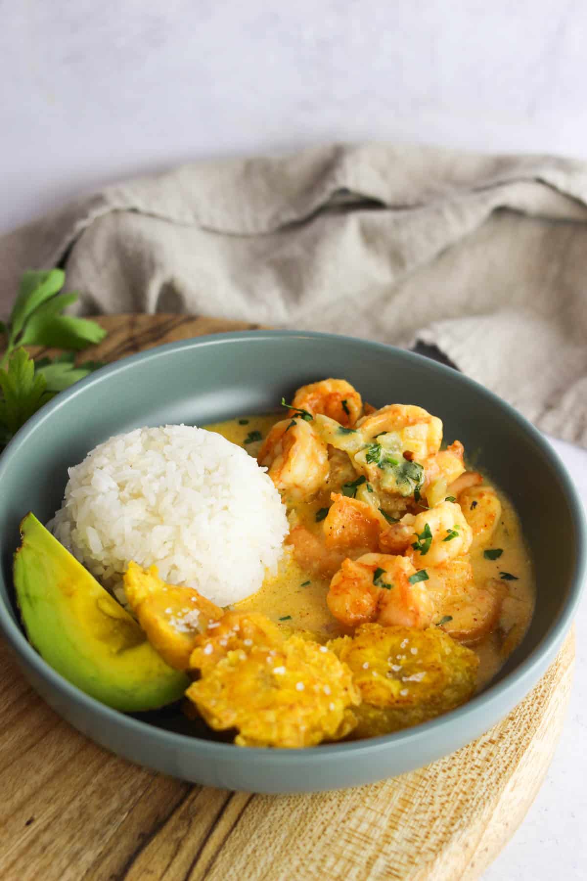 Serving of camarones al ajillo (garlic shrimp) with rice, plantains and avocado.