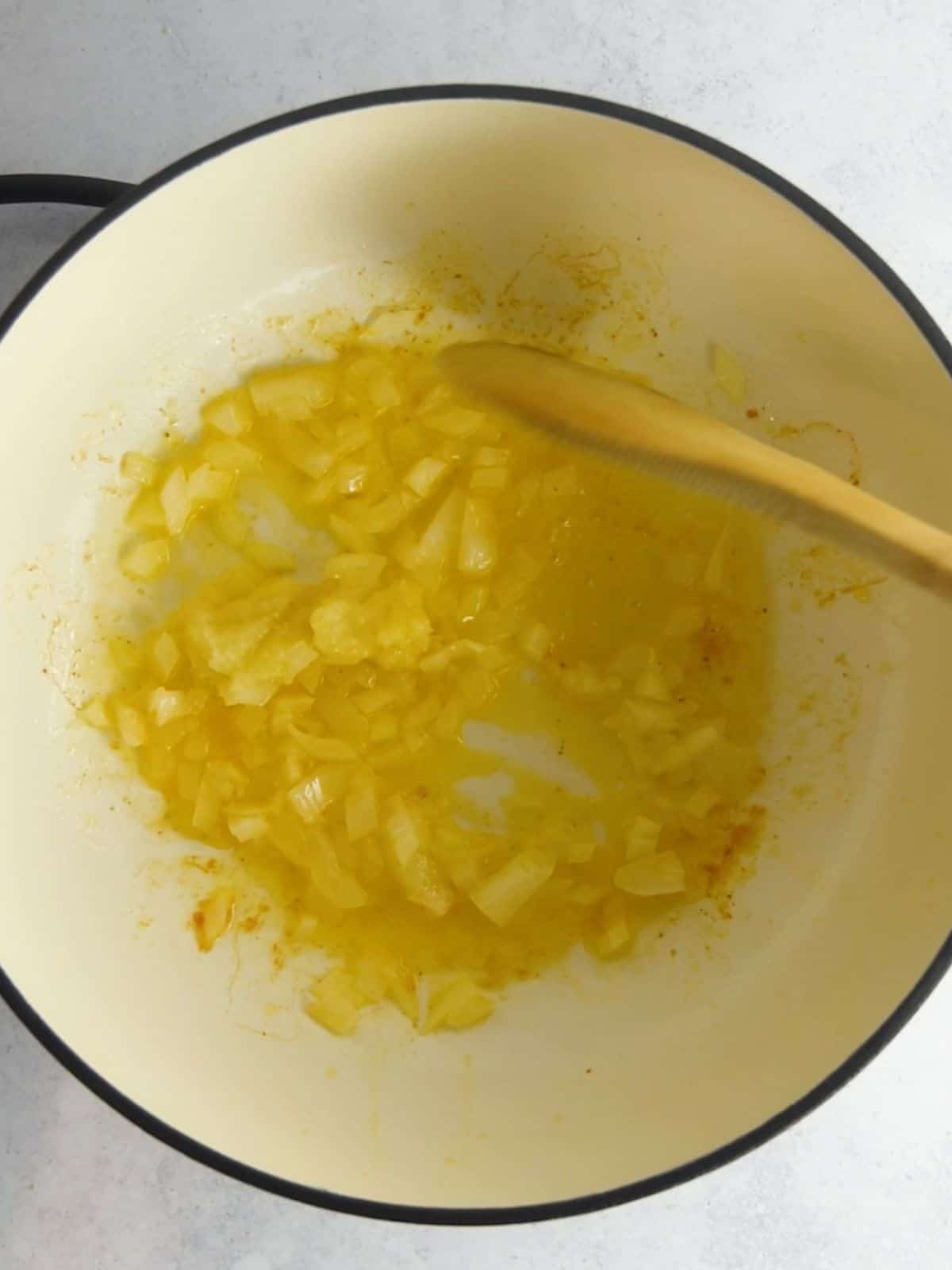 Onions and garlic cooking in a skillet.