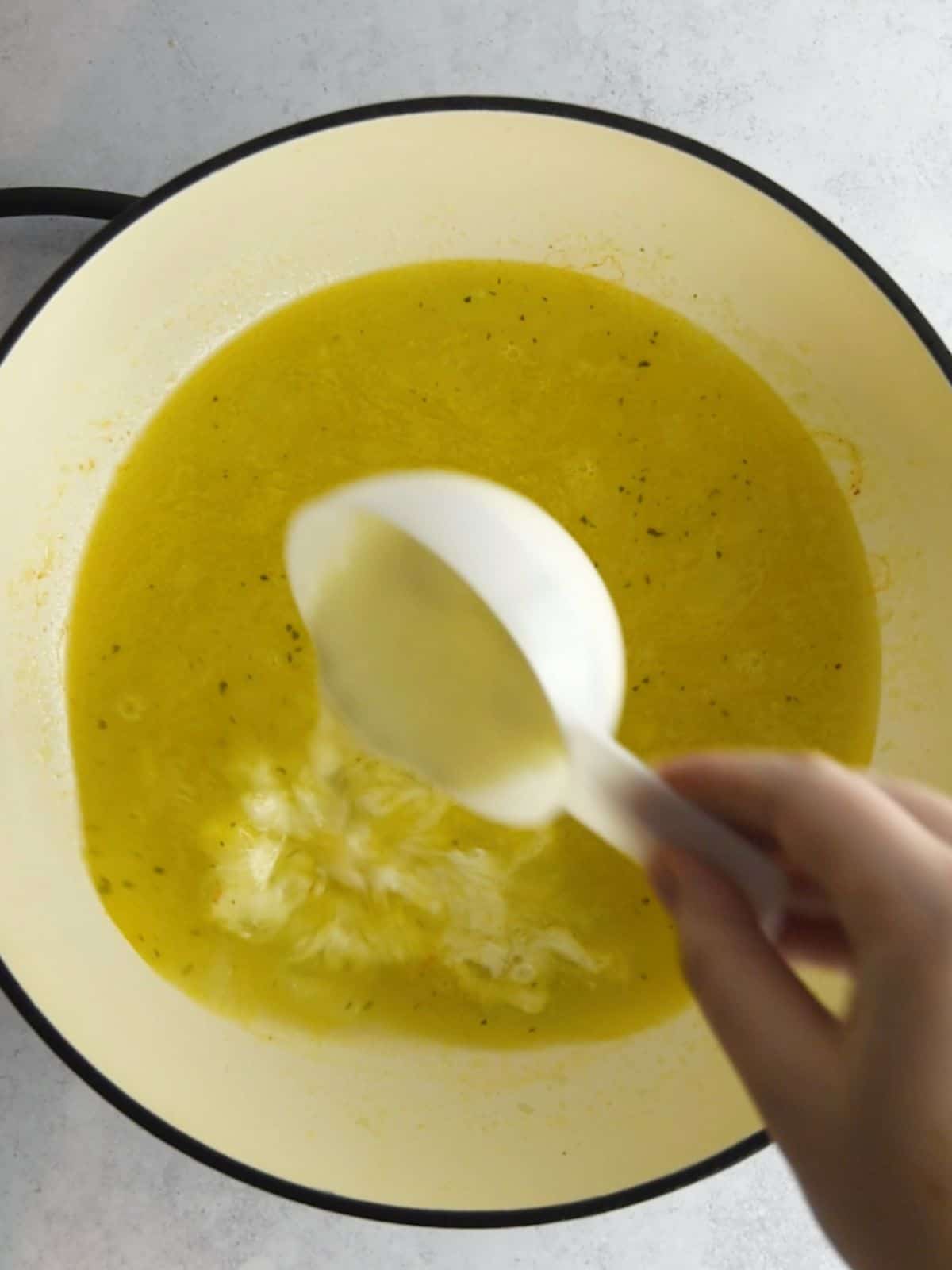 Adding heavy cream to the skillet.