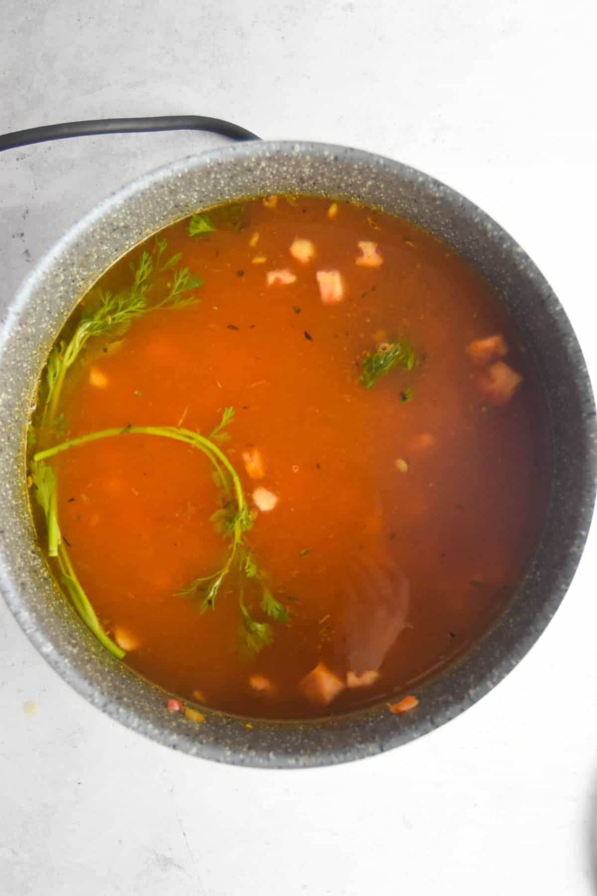 Broth added to the soup in a large pot.