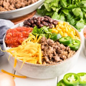 Taco bowl with all the toppings including ground beef, corn, cheese and salsa.