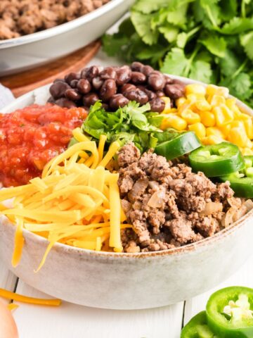 Taco bowl with all the toppings including ground beef, corn, cheese and salsa.