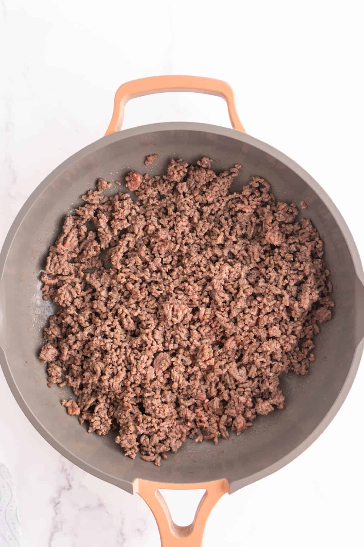 Ground beef cooking in a skillet.