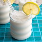 Limonada de coco served with a glass straw and a lime wheel.