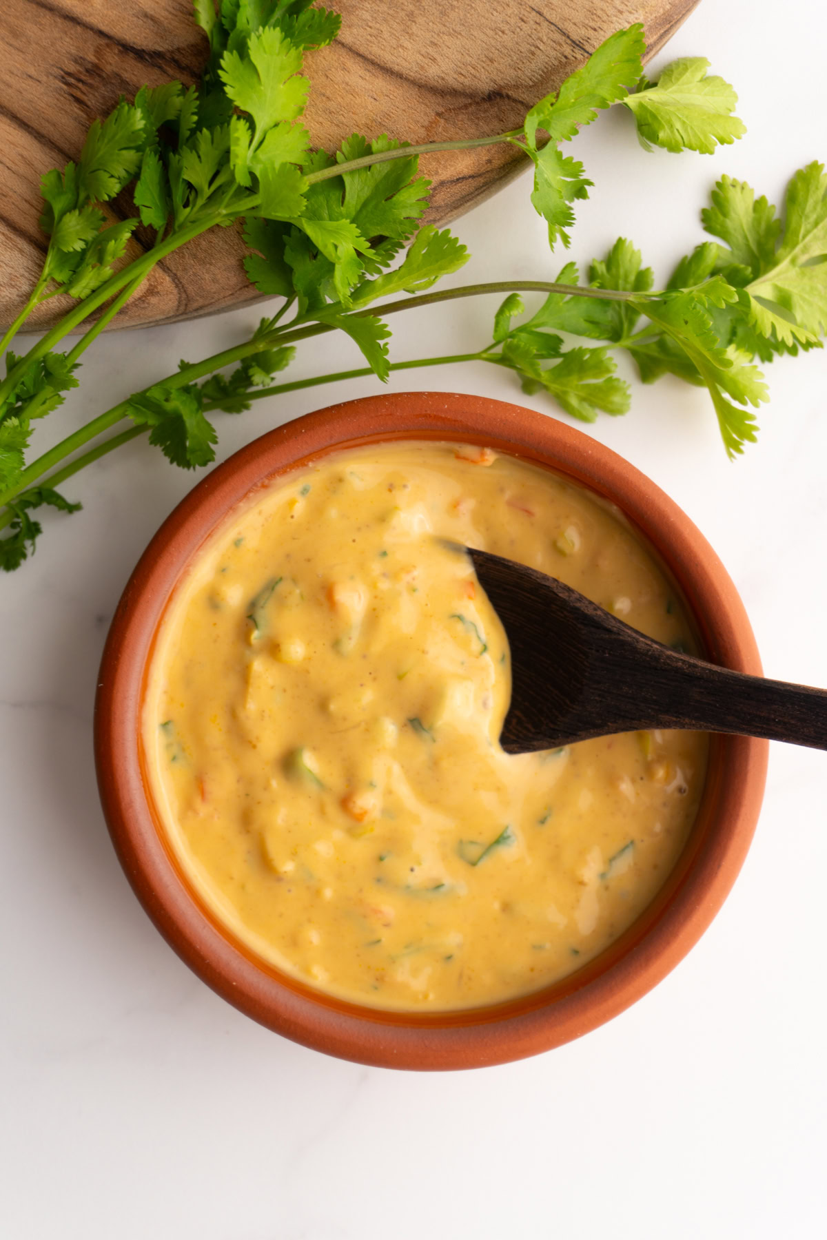 Peanut sauce in a bowl with a wooden spoon.