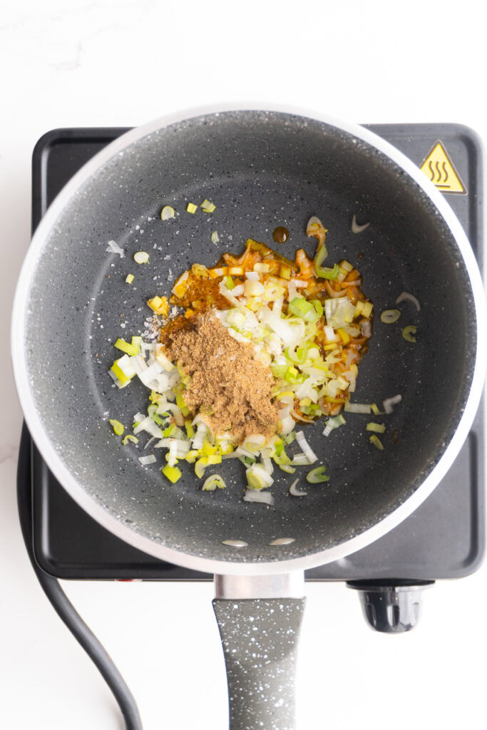 Achiote oil, onion, cumin and salt in a sauce pan.