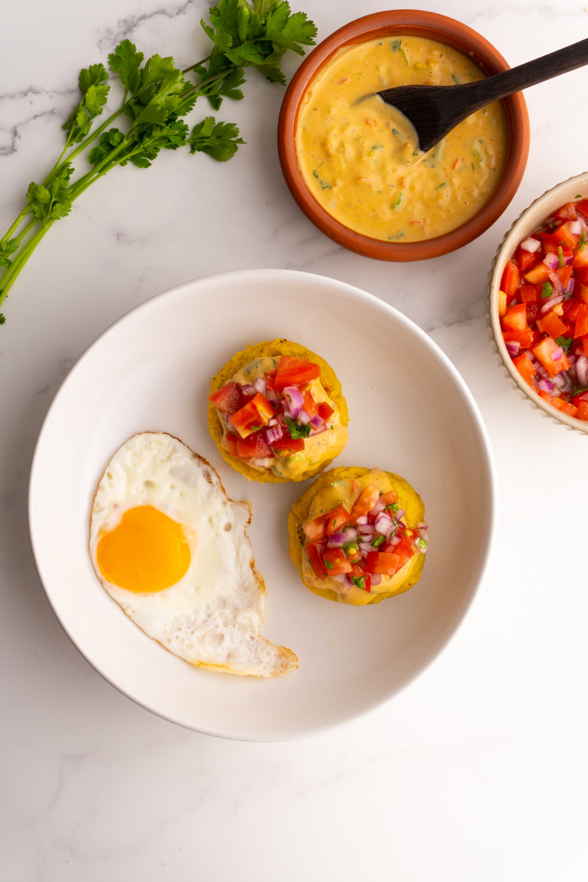 White shallow bowl served with tortillas de verde and a fried egg.