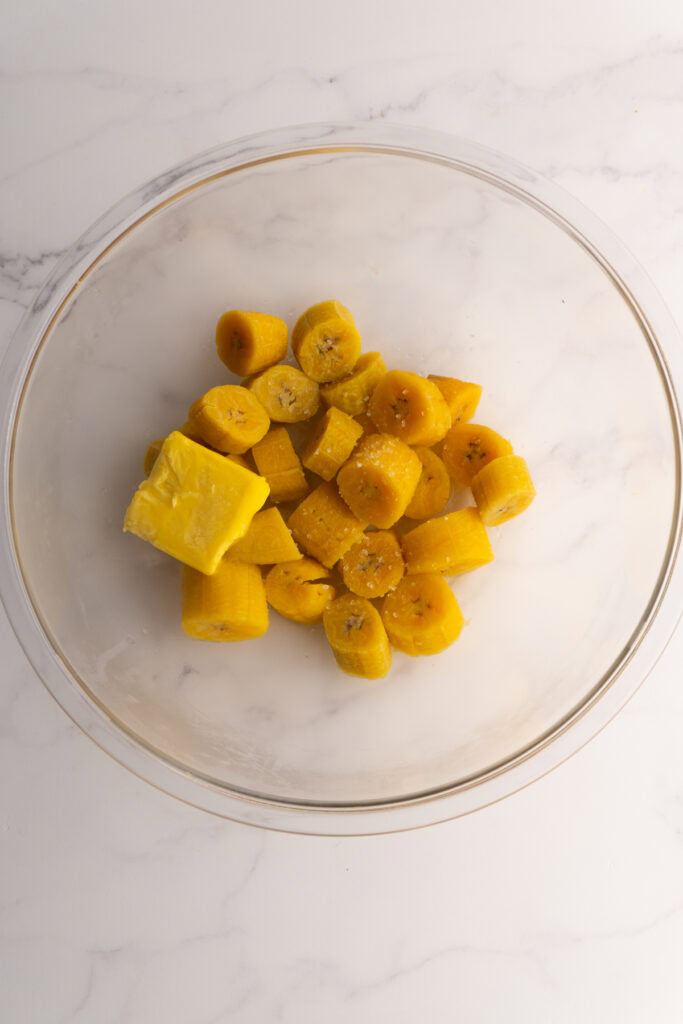 Boiled plantain in a bowl with butter and salt.