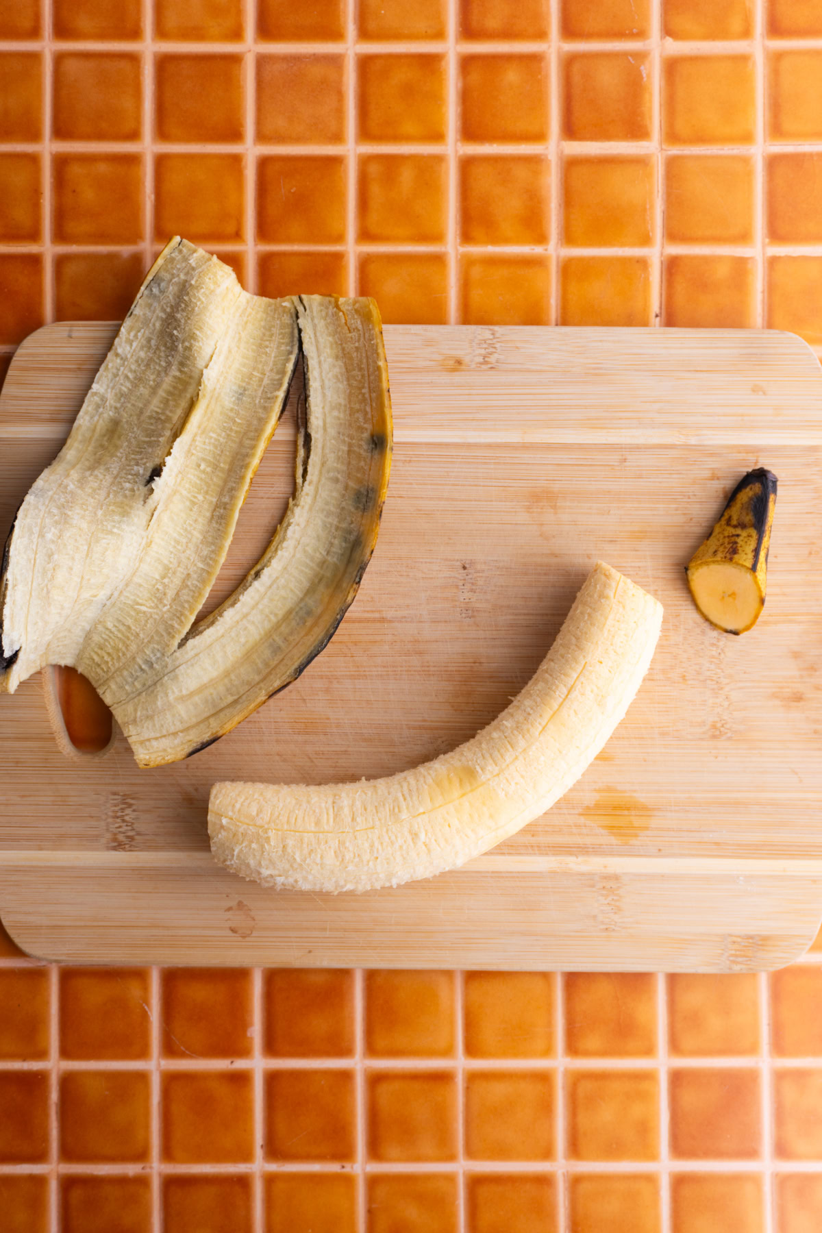 Sweet plantain after being peeled on a wooden board.