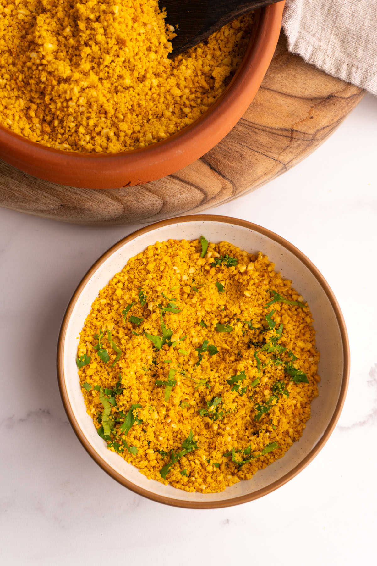 Salprieta in a white bowl next to a larger bowl of salprieta on a wooden board.