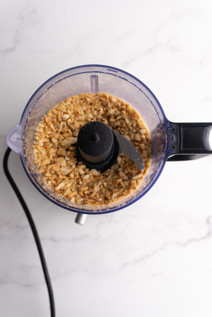 Peanuts in the food processor after being mixed a few times.