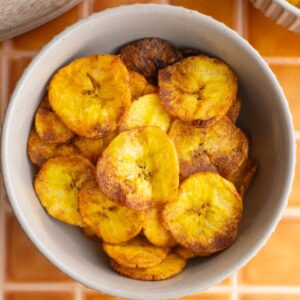 Close up of sweet plantain chips in a tan bowl.